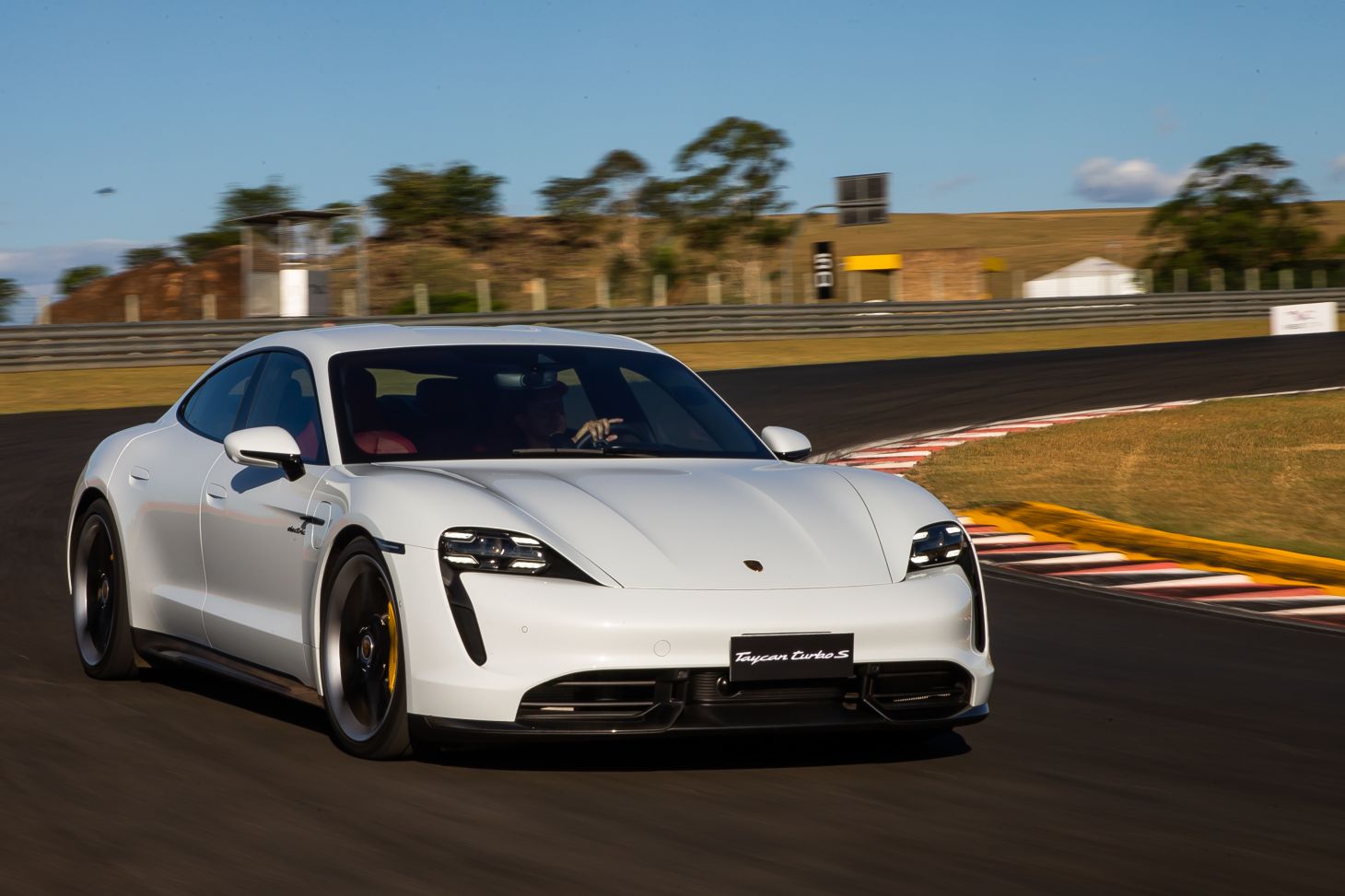 porsche taycan turbo s branco em movimento