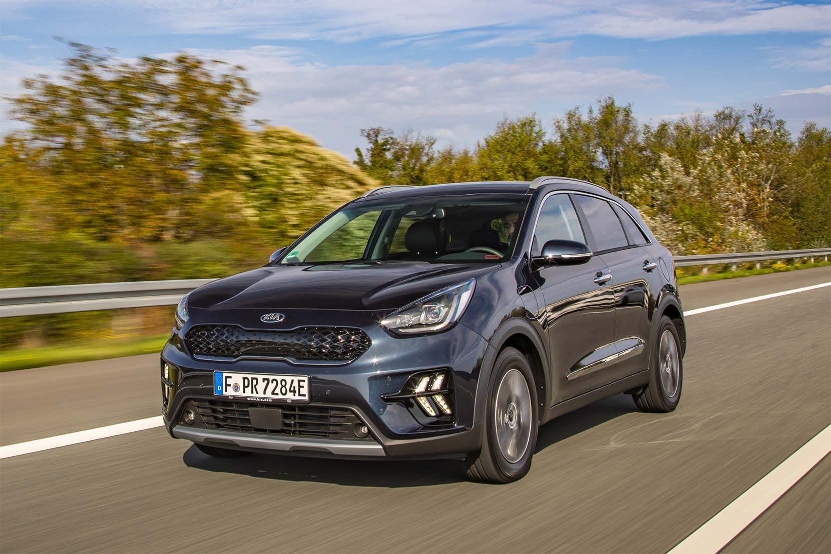 kia niro hybrid azul de grente em movimento