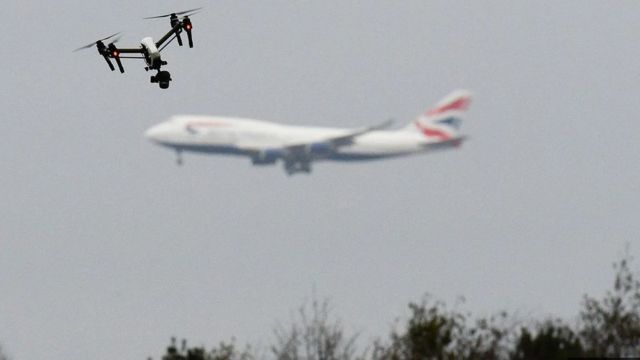 Drone voando em um parque no oeste de Londres com um avião de passageiros ao fundo