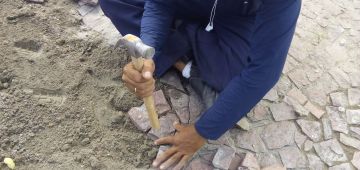 Reeducandos atuam na recolocação de pedras portuguesas na praça do Carmo, em Olinda