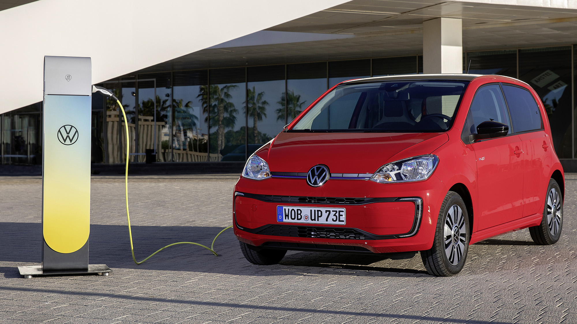 VW e-Up! elétrico vermelho com posto de carregamento