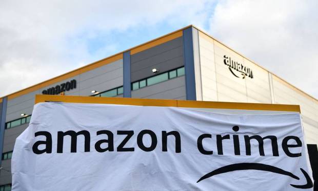 Ativistas do Extinction Rebellion (XR) afixaram cartaz com o logo 'Amazon Crime' (um trocadilho com o plano de assinatura Amazon Prime) ao bloquear a saída de um centro de distribuição da Amazon durante um protesto em Tilbury, a leste de Londres Foto: BEN STANSALL / AFP