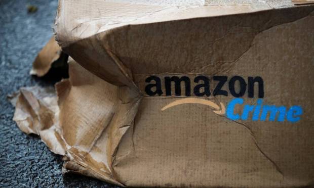 Caixa de papelão amassada está estampada com logo do plano de assinatura da Amazon modificado para protestar no centro de distribuição em Altrincham, perto de Manchester Foto: CARL RECINE / REUTERS